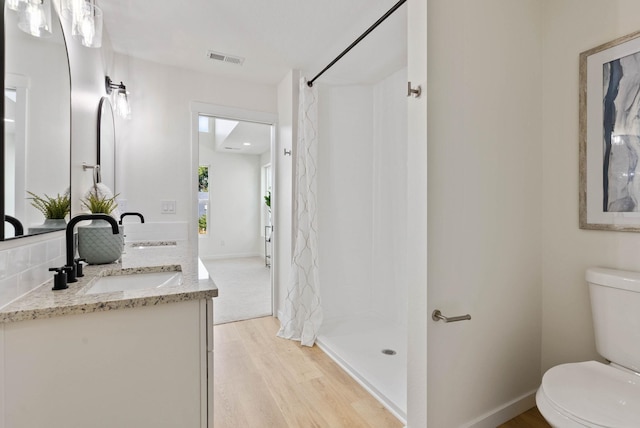 bathroom with backsplash, vanity, a shower with shower curtain, hardwood / wood-style flooring, and toilet