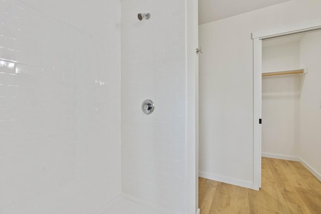 bathroom featuring hardwood / wood-style flooring and tiled shower