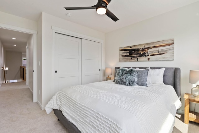 carpeted bedroom featuring ceiling fan and a closet