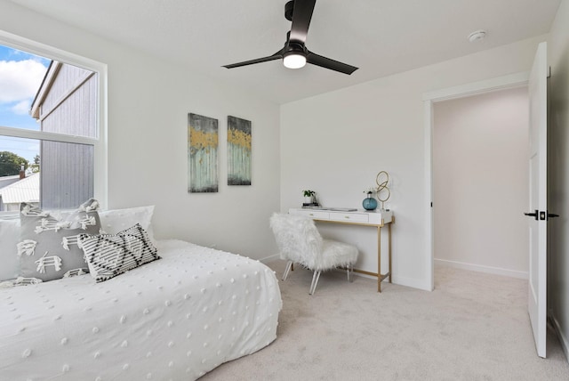 bedroom featuring ceiling fan, multiple windows, and light carpet