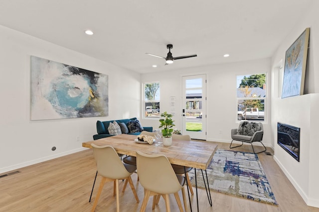 dining space with light hardwood / wood-style floors, ceiling fan, and a wealth of natural light