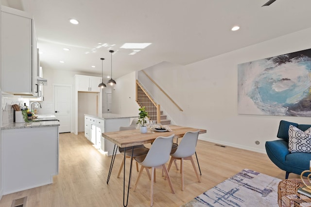 dining space featuring sink and light hardwood / wood-style flooring