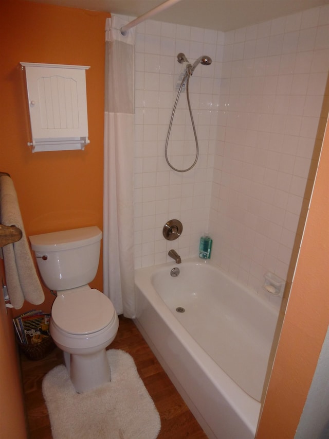 bathroom with shower / tub combo with curtain, wood-type flooring, and toilet