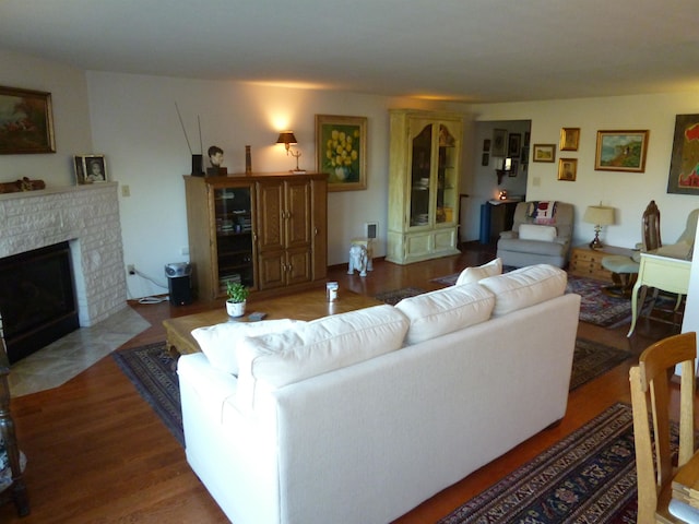 living room with hardwood / wood-style flooring and a brick fireplace