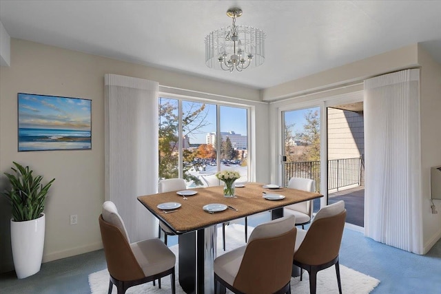 dining space with carpet and a notable chandelier