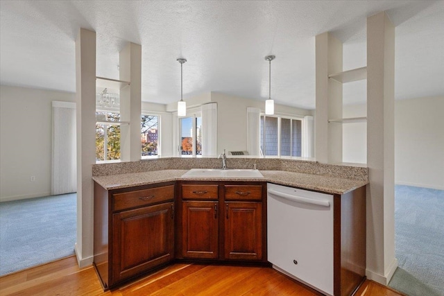 kitchen with dishwasher, decorative light fixtures, light wood-type flooring, and sink