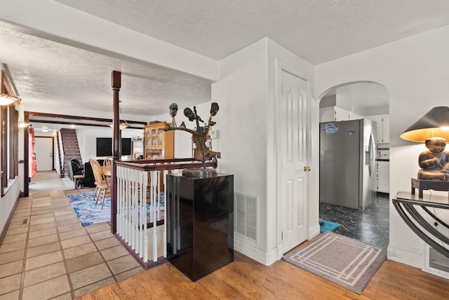 hallway featuring wood-type flooring and a textured ceiling