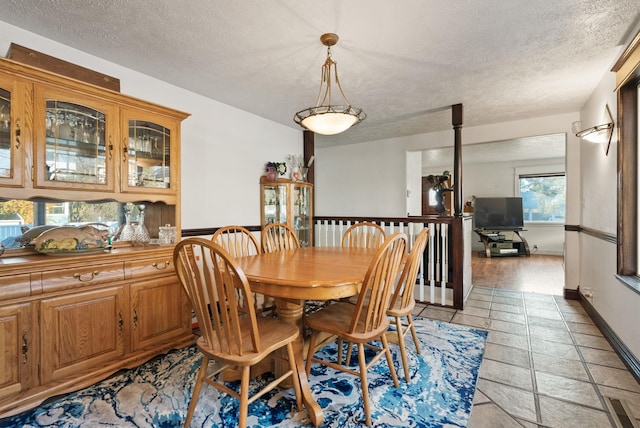 dining space with light wood-type flooring and a textured ceiling