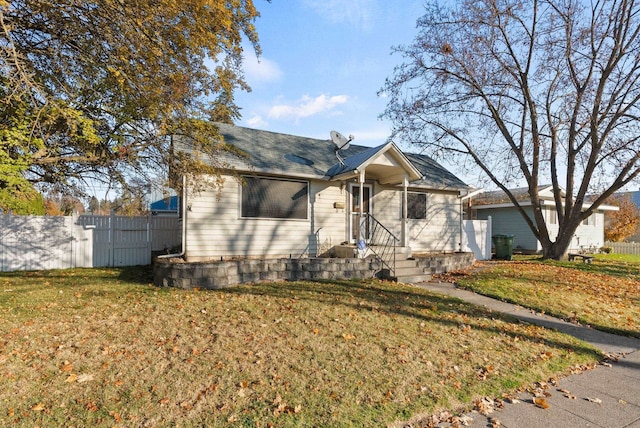 bungalow-style home with a front yard