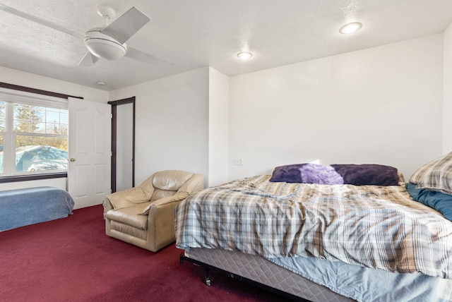 carpeted bedroom featuring ceiling fan and a textured ceiling