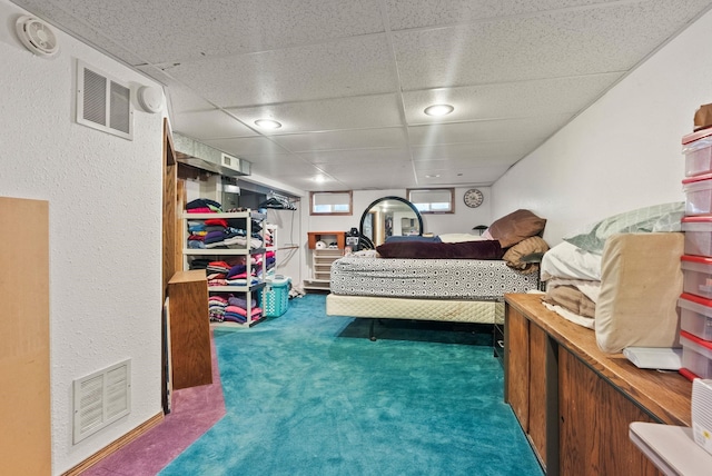 bedroom featuring dark colored carpet and a drop ceiling