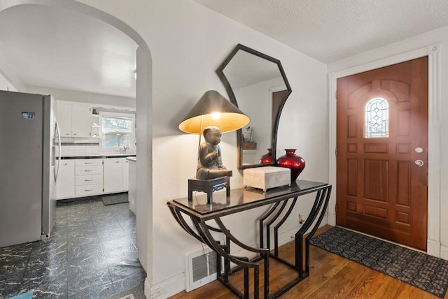 entryway featuring dark hardwood / wood-style floors, a healthy amount of sunlight, and a textured ceiling