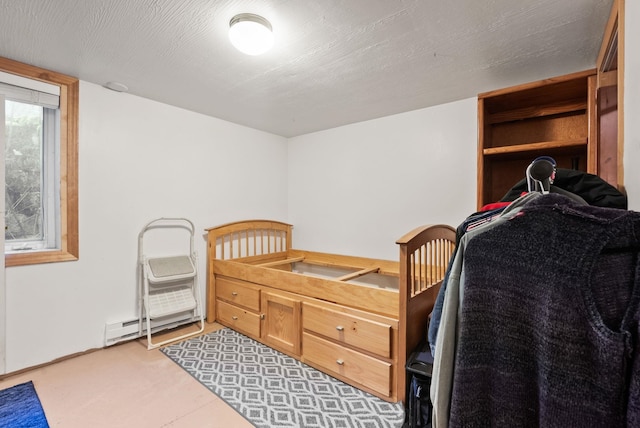 bedroom featuring a textured ceiling and a baseboard heating unit