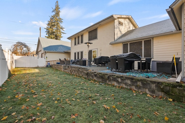 back of house featuring a lawn and a patio area