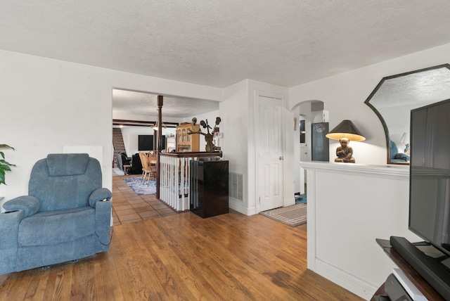 living room featuring wood-type flooring and a textured ceiling