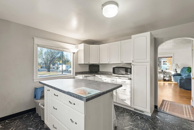 kitchen featuring white cabinetry, a wealth of natural light, and a kitchen island