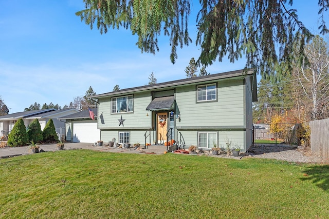 raised ranch featuring a front lawn and a garage