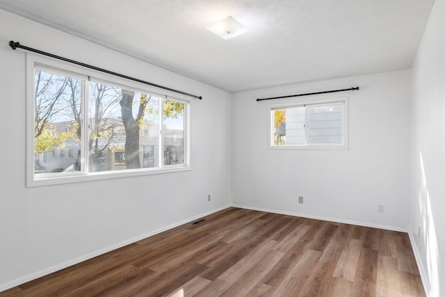 unfurnished room featuring baseboards and wood finished floors