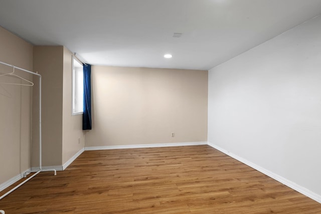 interior space with baseboards, wood finished floors, and recessed lighting