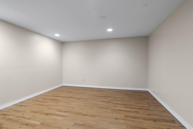 spare room featuring light wood-style floors, recessed lighting, and baseboards