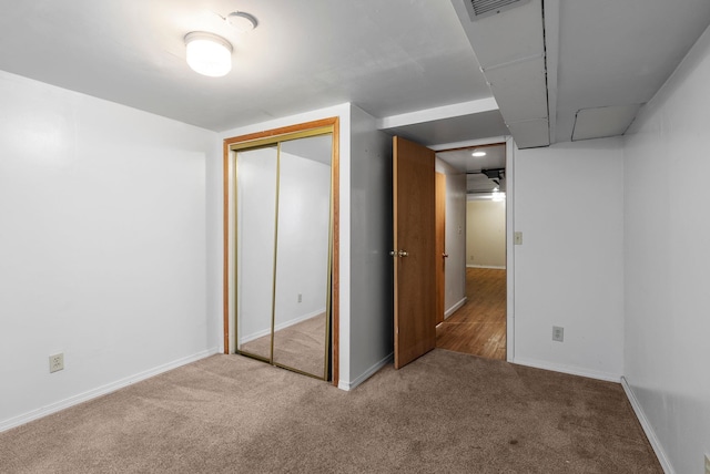 unfurnished bedroom featuring carpet floors, a closet, visible vents, and baseboards