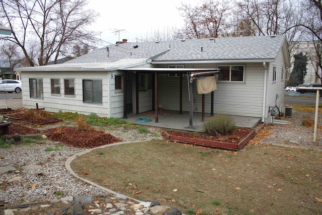 rear view of property with central AC, a shingled roof, and a patio area