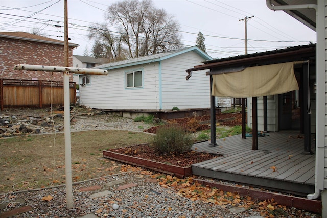 view of property exterior with fence and a deck