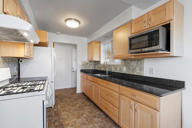 kitchen with white gas range oven, stainless steel microwave, light brown cabinetry, under cabinet range hood, and a sink