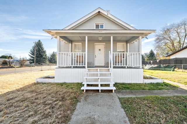 bungalow featuring covered porch and a front lawn