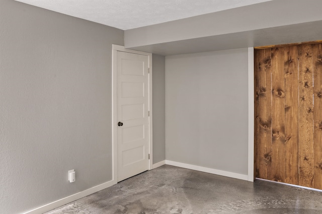 unfurnished room featuring concrete flooring and a textured ceiling