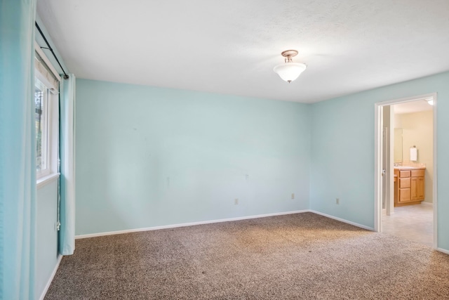 unfurnished bedroom featuring carpet flooring and ensuite bathroom