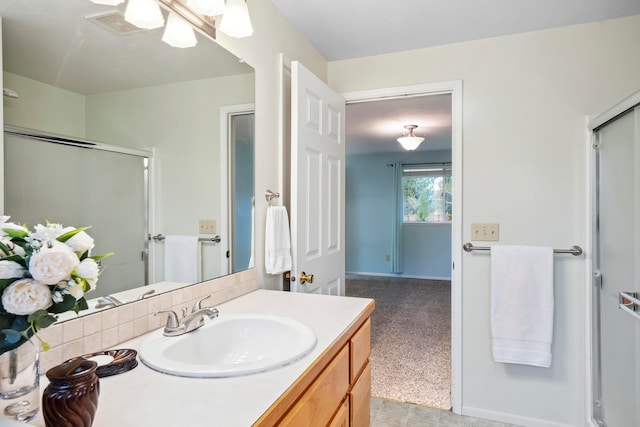 bathroom featuring vanity and a shower with door