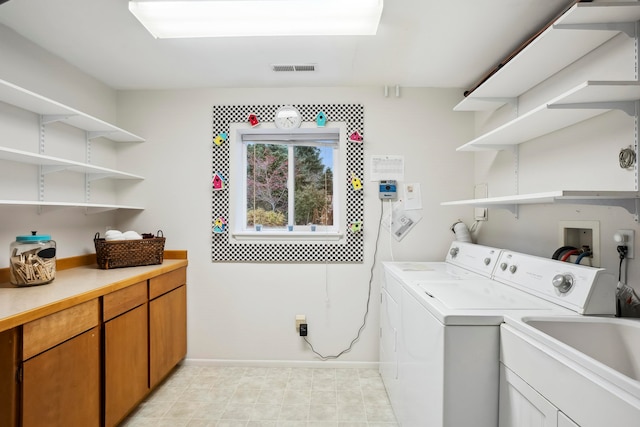 laundry room with cabinets, separate washer and dryer, and sink