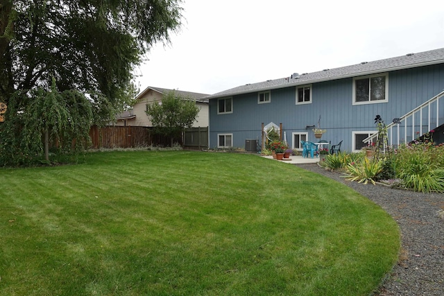 rear view of property featuring central AC, a yard, and a patio area