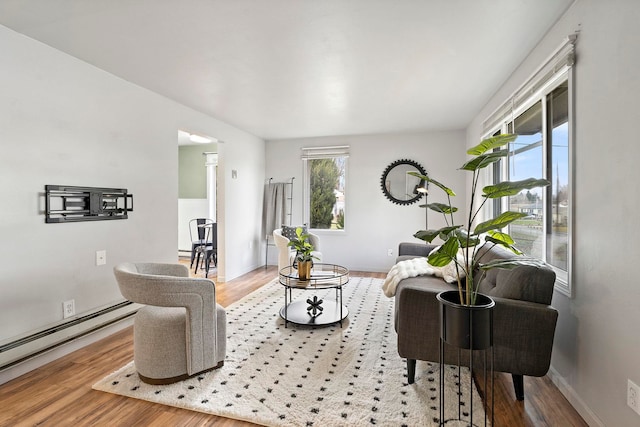 living room featuring wood-type flooring and a baseboard heating unit