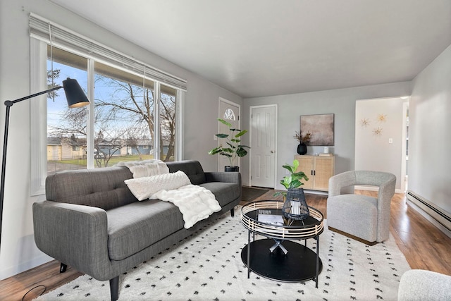 living room with baseboard heating and light hardwood / wood-style floors