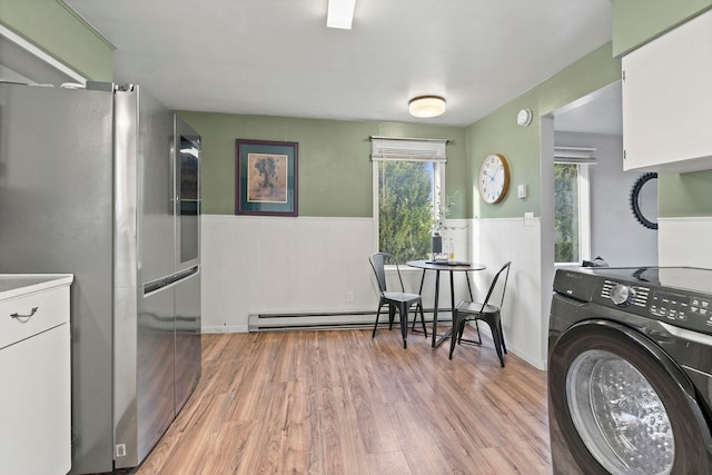 laundry room with a baseboard radiator, light wood-type flooring, and washer / dryer