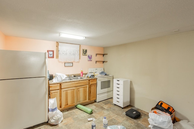 kitchen featuring sink, white appliances, and a textured ceiling