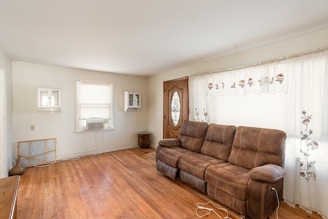 living room with wood-type flooring, cooling unit, and a healthy amount of sunlight