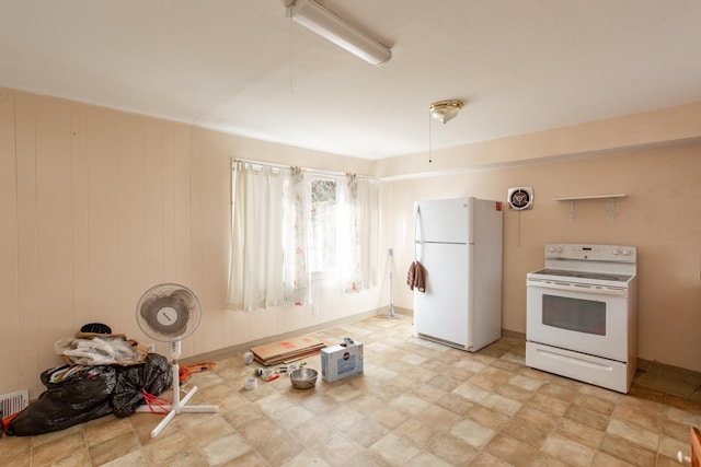 kitchen featuring wooden walls and white appliances