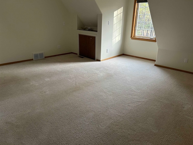 interior space with light colored carpet and vaulted ceiling