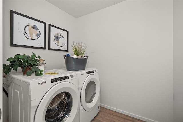 clothes washing area featuring washer and clothes dryer and dark hardwood / wood-style flooring