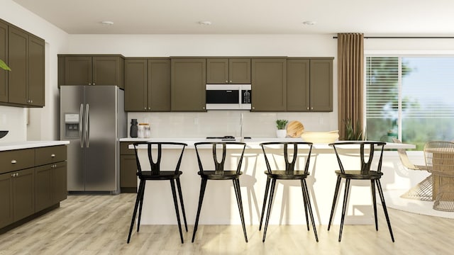 kitchen with stainless steel refrigerator with ice dispenser, light hardwood / wood-style flooring, tasteful backsplash, and a breakfast bar