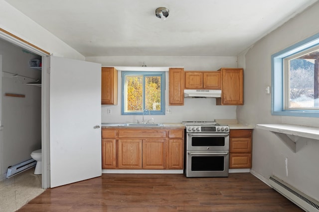 kitchen featuring baseboard heating, sink, dark wood-type flooring, and range with two ovens