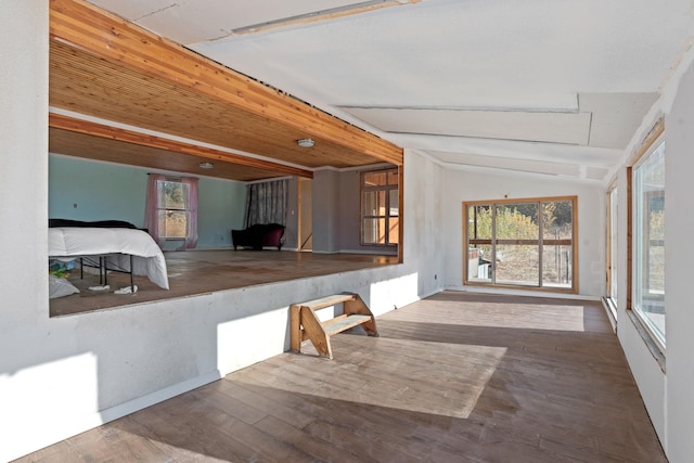 interior space featuring hardwood / wood-style floors and vaulted ceiling with beams