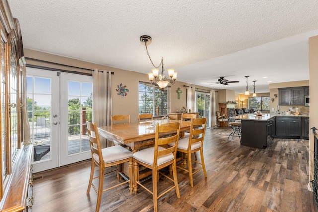 dining space featuring ceiling fan with notable chandelier, french doors, dark hardwood / wood-style flooring, and a textured ceiling