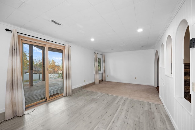 spare room featuring ornamental molding and light wood-type flooring