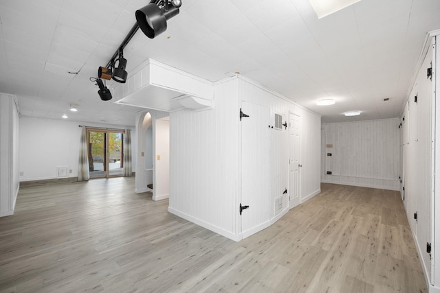 empty room featuring wooden walls and light hardwood / wood-style flooring