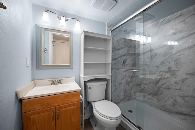 bathroom featuring vanity, toilet, and a shower with shower door