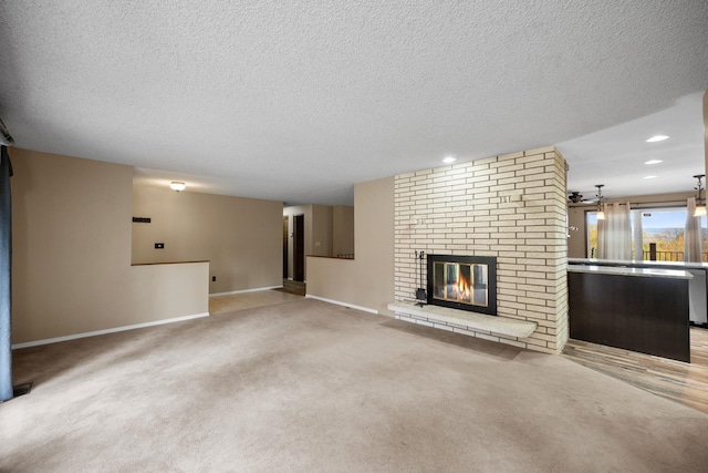 unfurnished living room featuring a textured ceiling, light colored carpet, and a brick fireplace